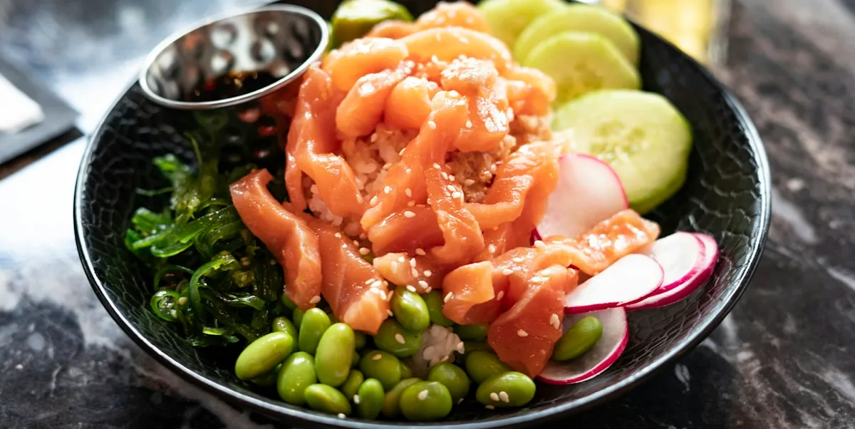 Salmon poke bowl with edamame, cucumber and seaweed salad